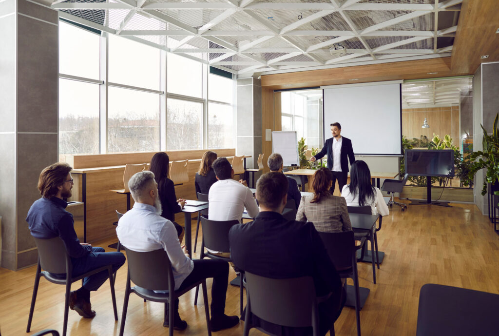 Psychologist presenting to seated group in modern Clarity Psychology seminar room