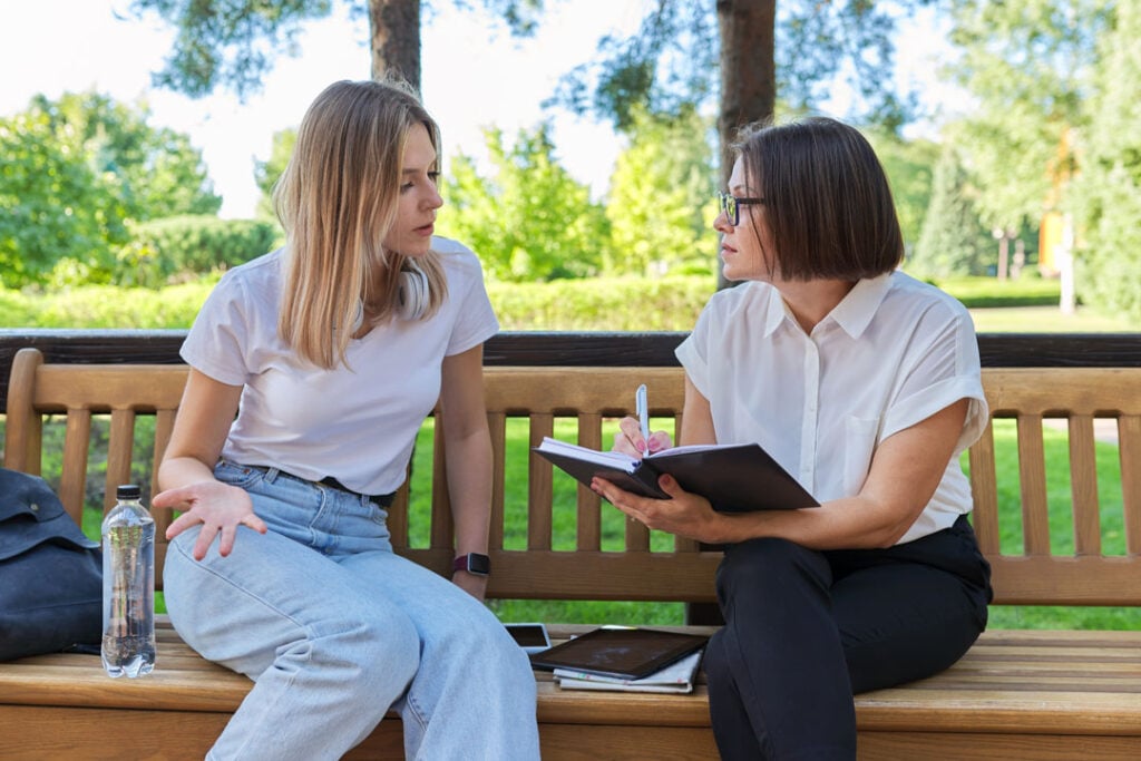 Two women in discussion outdoors during clinical supervision at Clarity Psychology.