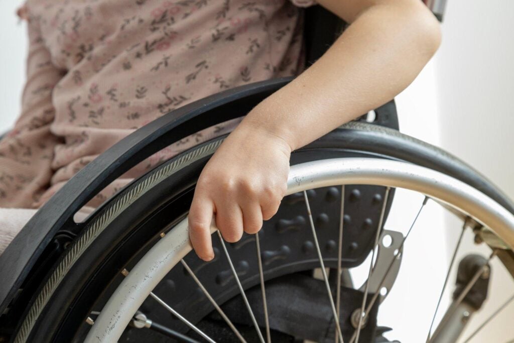 Child's hand holding wheel of mobility aid at Clarity Psychology clinic