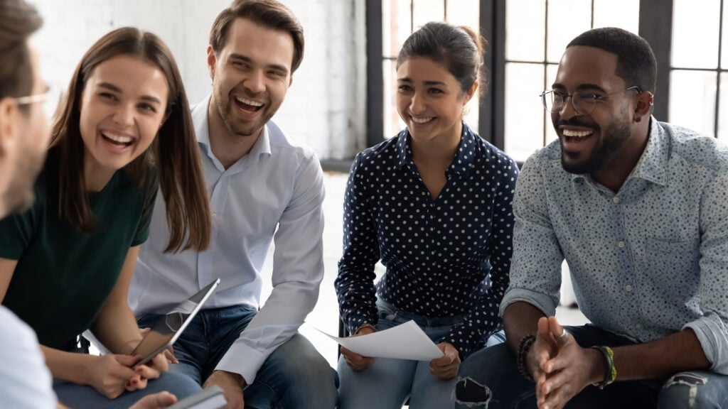 Smiling adults holding papers during group session at Clarity Psychology clinic